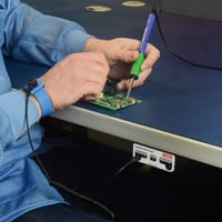 How do single-wire ESD wrist strap monitors detect if the strap is worn correctly?